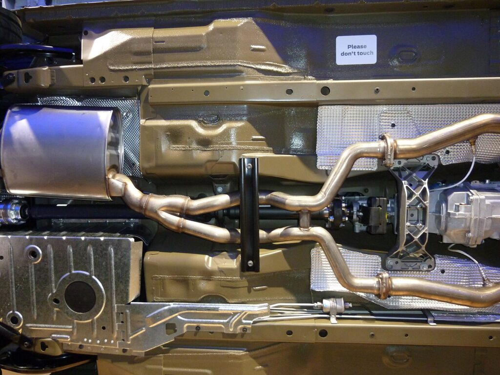 Imagem de apoio com escapamento automotivo em oficina ou loja de peças, relacionada ao artigo Tipos de Escapamento: Traseiro, Intermediário e Completo da SOS Escapamentos.